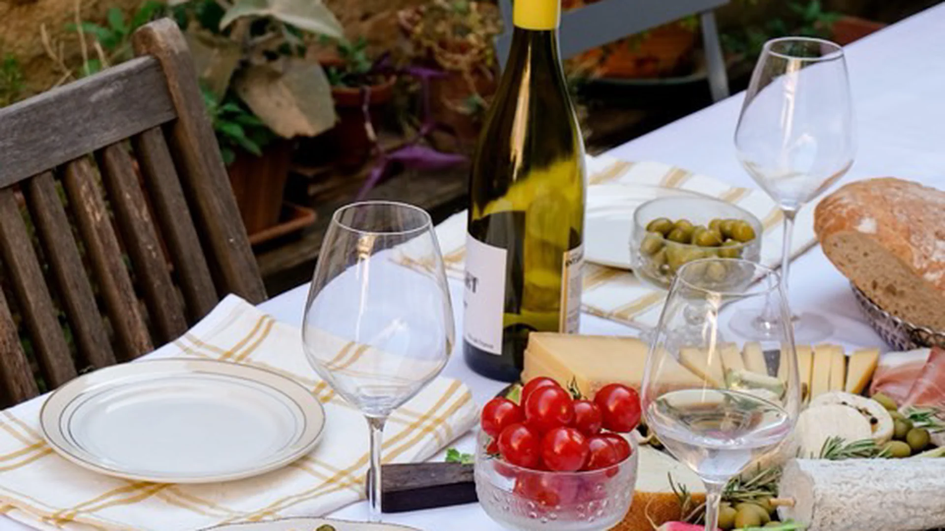 Outdoor French-style table set with wine, charcuterie and cheese for an intimate women’s retreat in the Camargue.